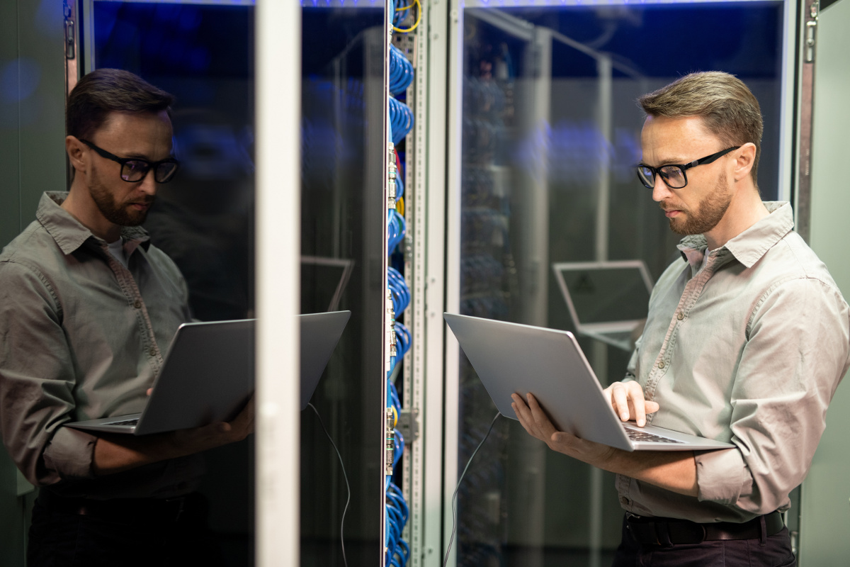 IT Service Technician with Laptop in Server Room